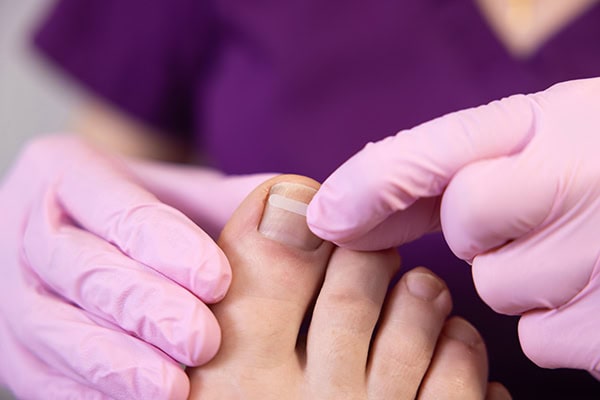 A person getting their toe checked by a doctor